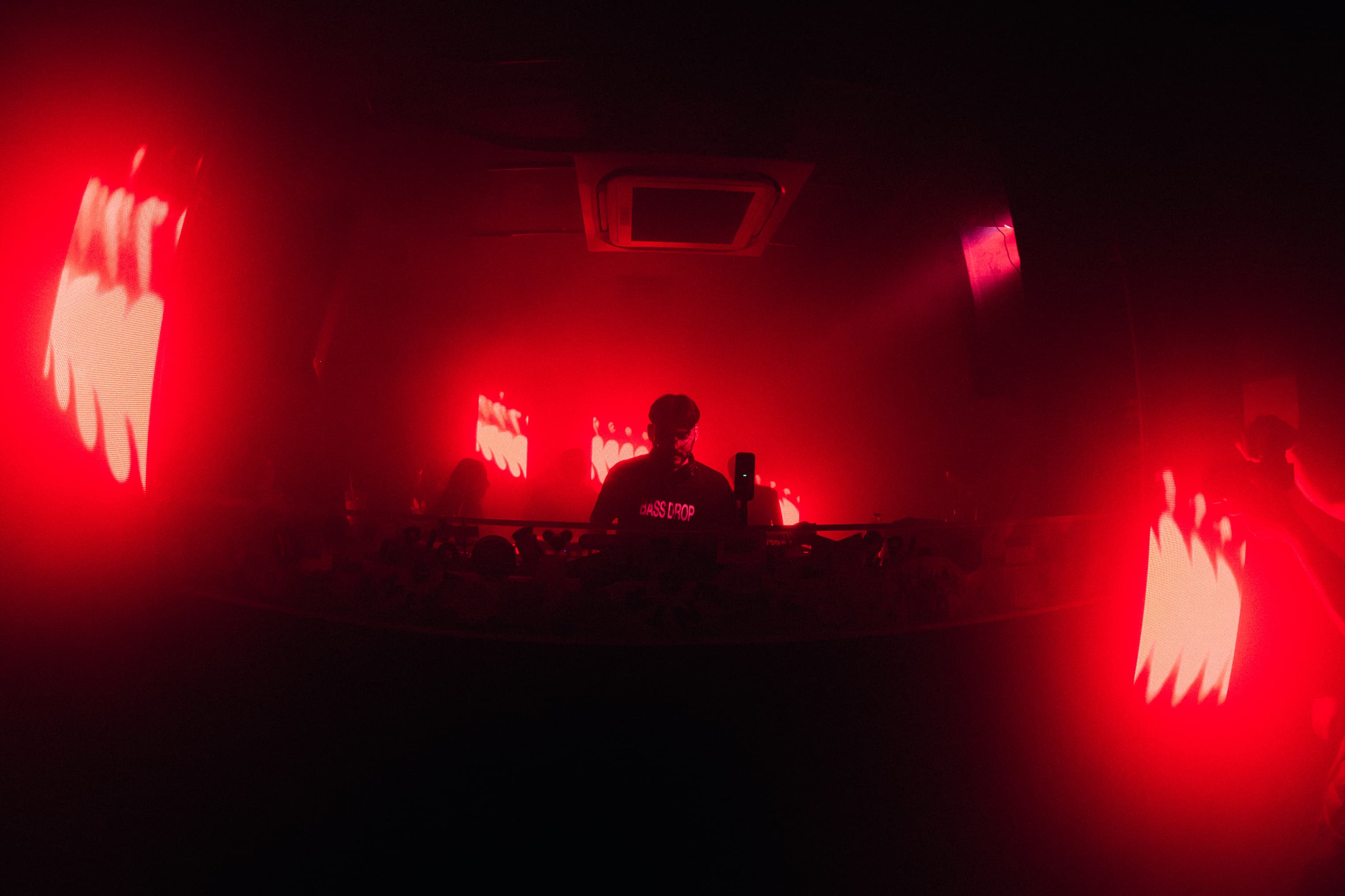 Roger Rave performing a live set surrounded by intense stage lighting.
